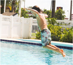 Little boy jumping into pool